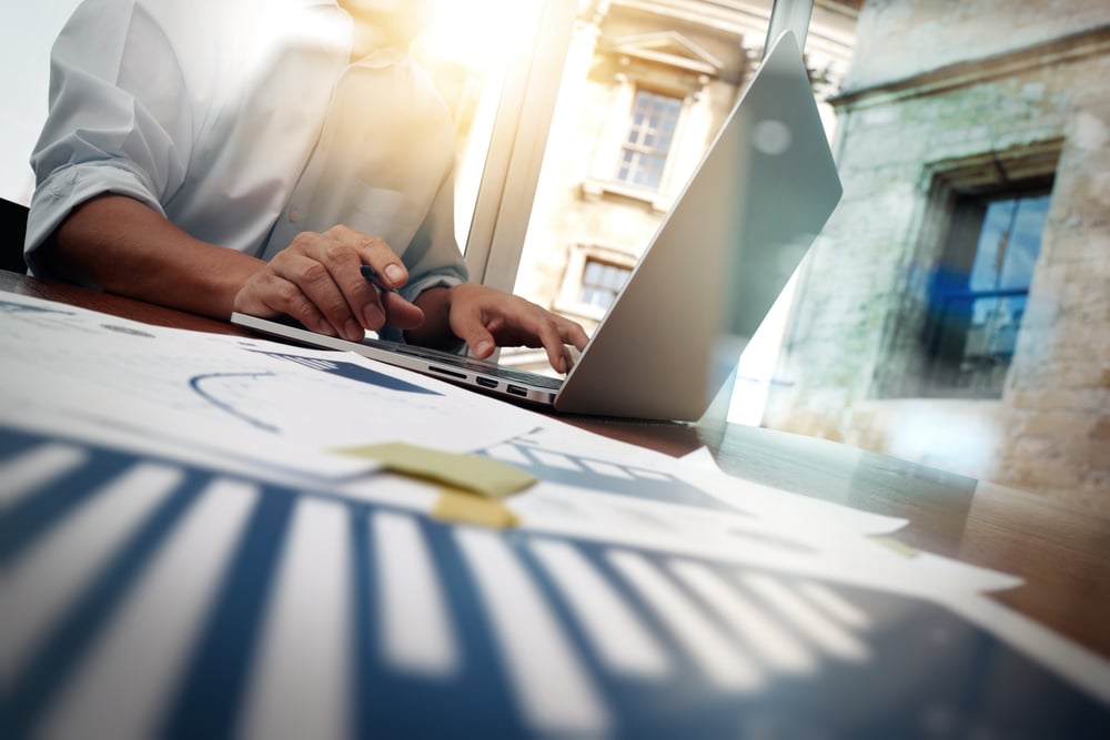 business documents on office table with smart phone and digital tablet and graph financial diagram and man working in the background-2